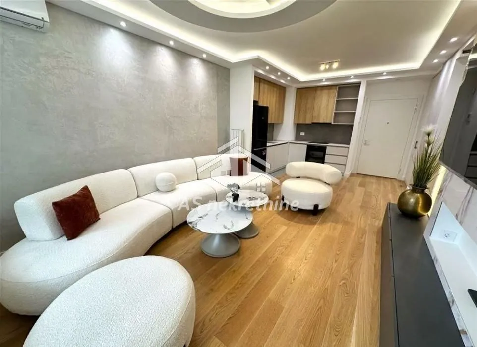 Living room with a sofa set and a view towards the kitchen in the background.