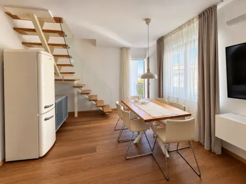 Living room with dining area and stairs. - image 17