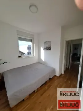 Manja spavaća soba sa bračnim krevetom i prozorom. - image 11