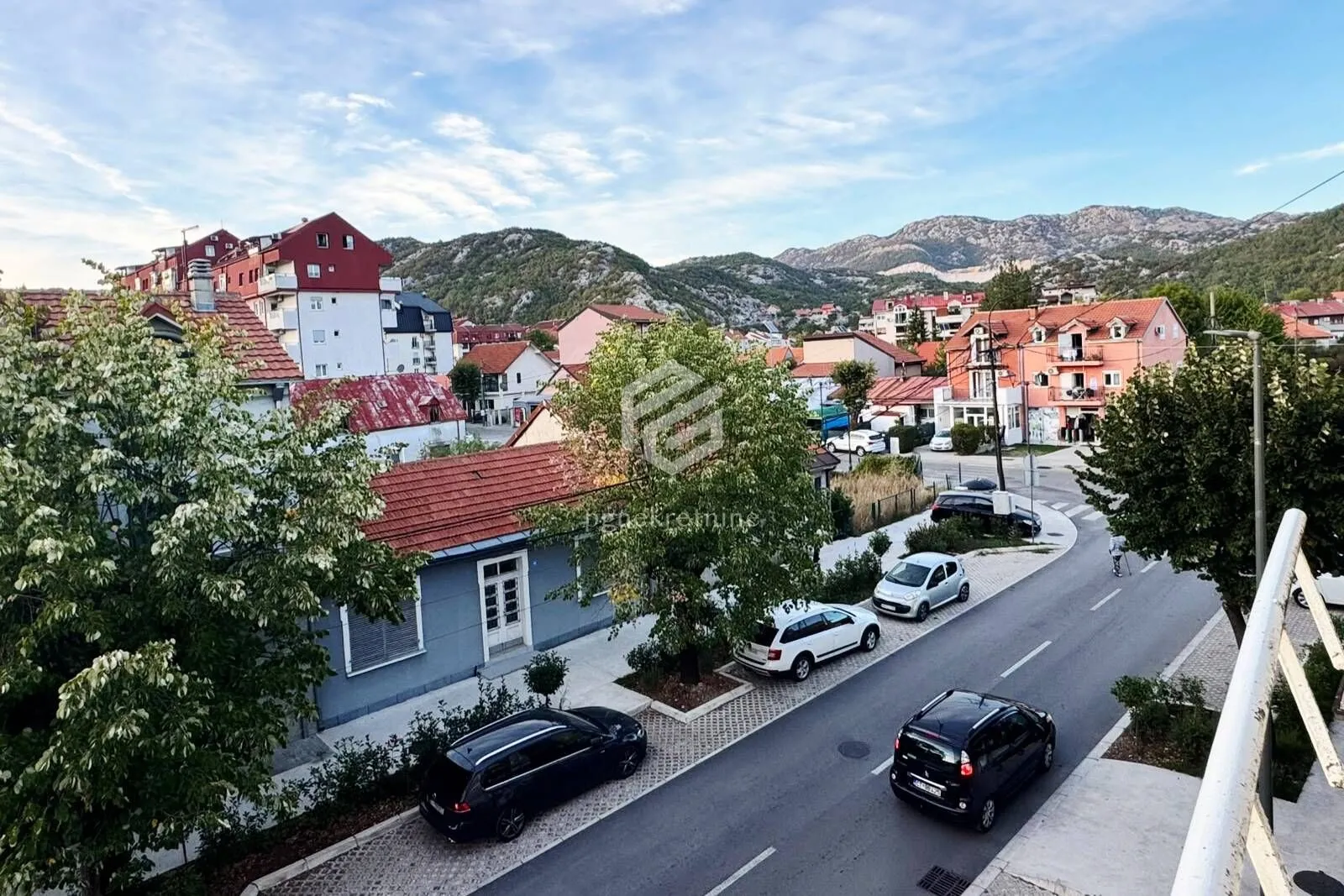 Pogled sa terase na ulicu i okolne planine.