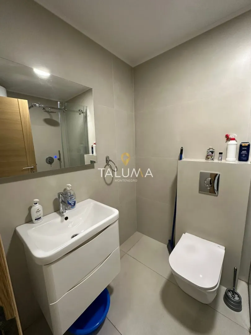 Modern bathroom equipped with a washbasin and a wall-mounted toilet.