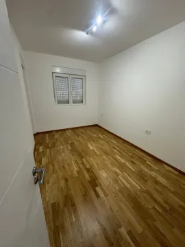 Empty room with hardwood flooring and white walls. - image 7