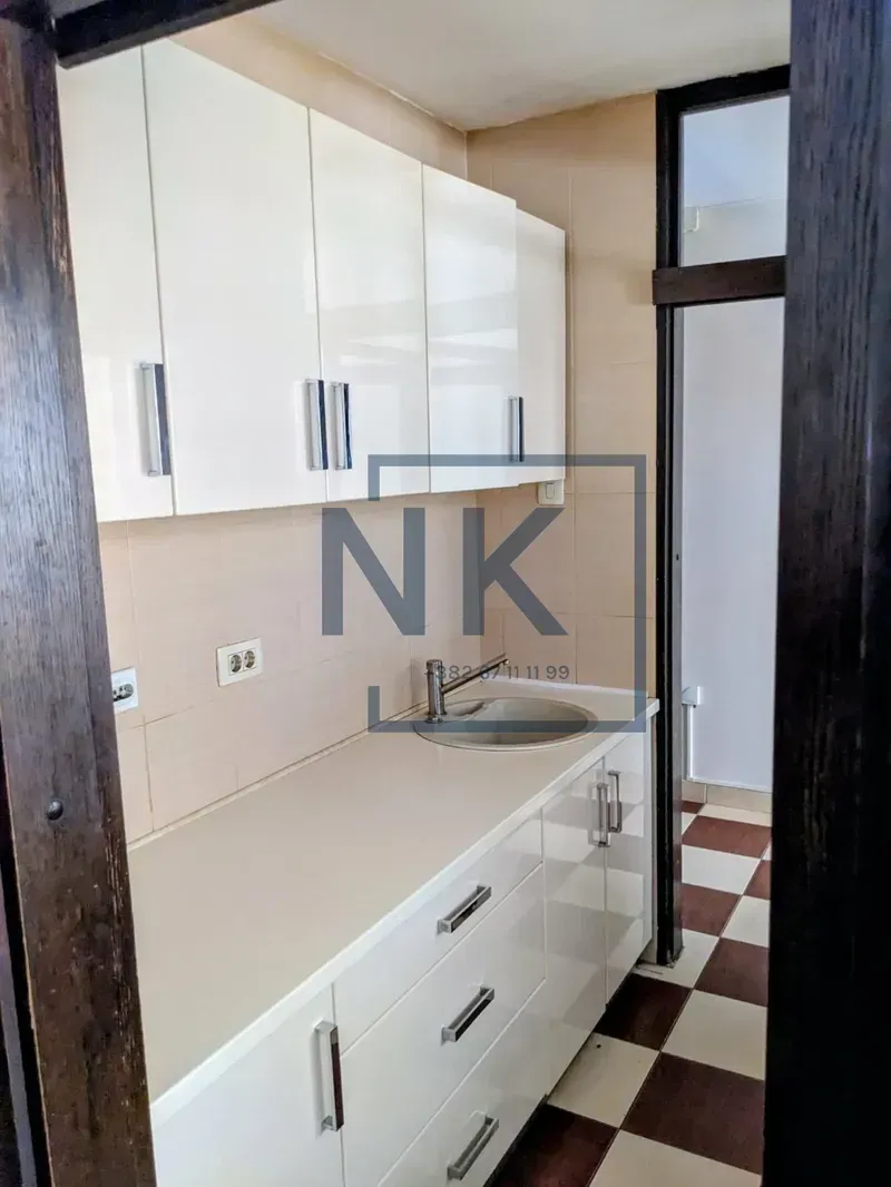Small kitchen with white cabinets and a sink.
