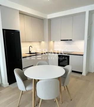 Modern kitchen with a dining table and white cabinets. - image 3