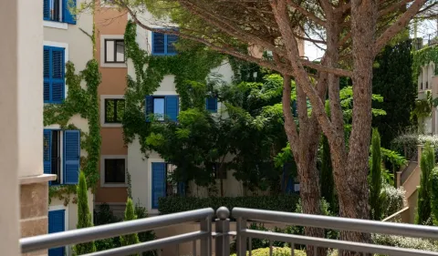 Pogled sa terase na zgradu okruženu zelenilom i drvećem. - image 10