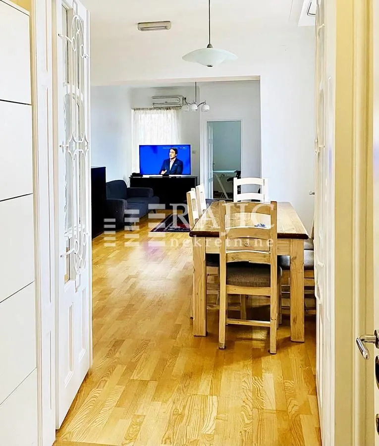 View from the hallway into a bright living room with a dining area.