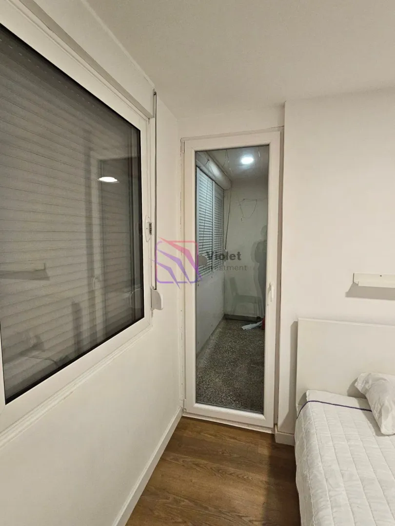 Bedroom with a bed, window, and access to the terrace.