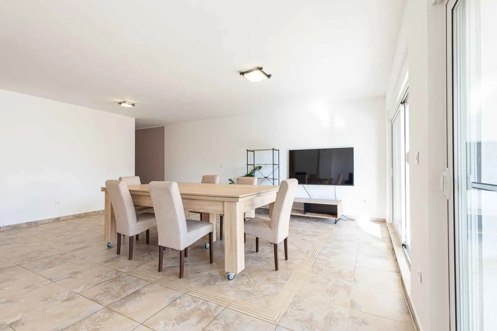 Spacious living room with a dining table and a television.
