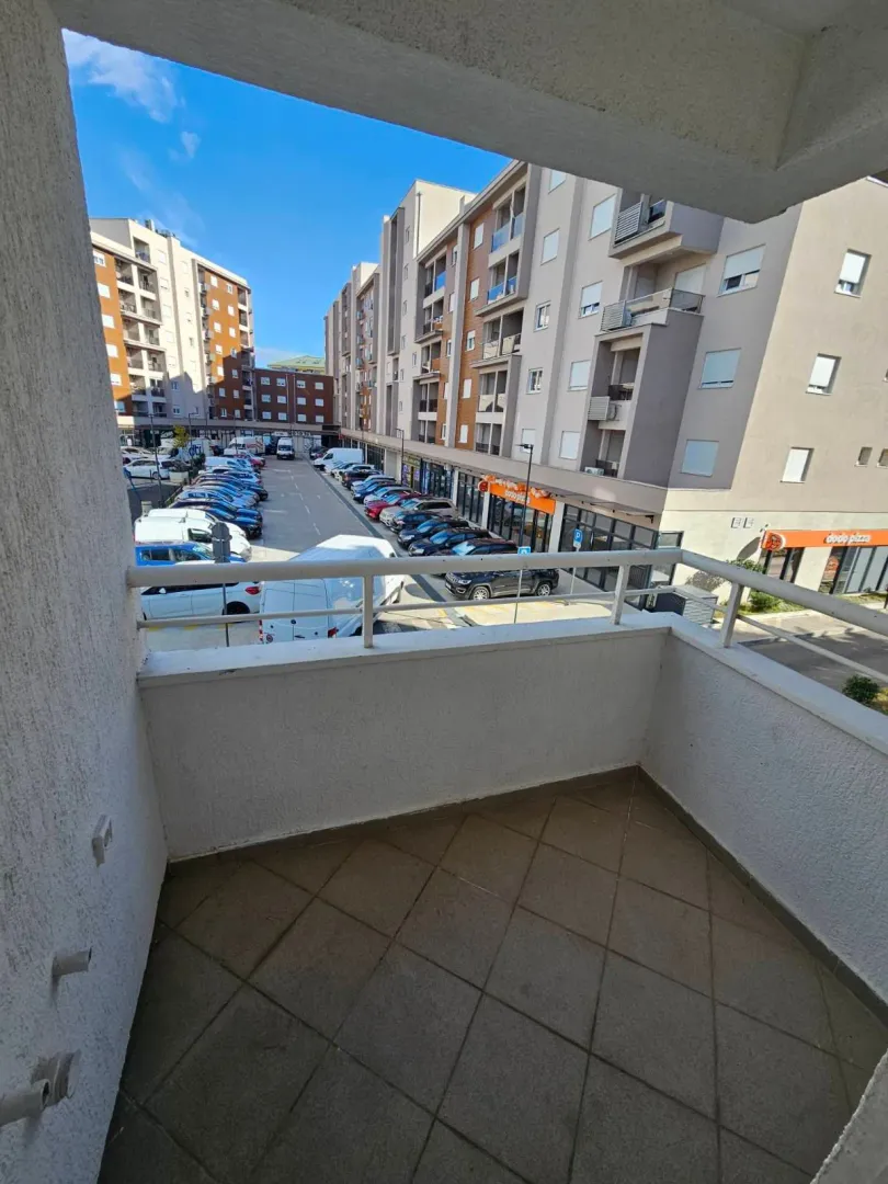 View from the balcony overlooking the parking lot and surrounding residential buildings.