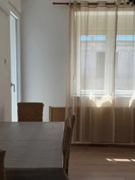 Dining area with a table, chairs, and a window with curtains. - image 5