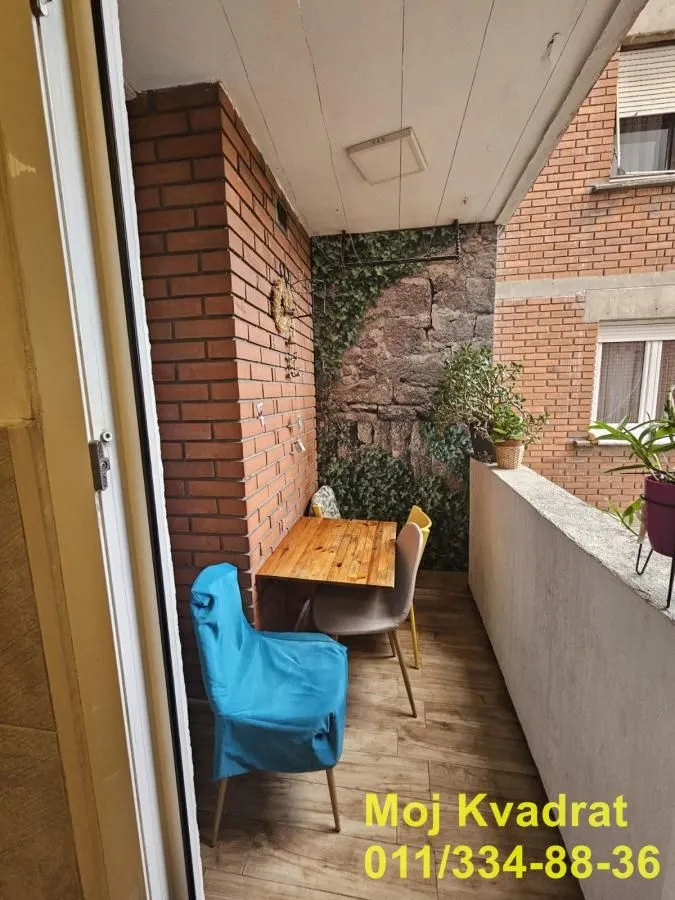 Manji zatvoreni balkon sa stolom i stolicama.