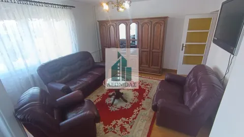 Living room with a seating set, a wooden wardrobe, and a wall-mounted TV. - image 7