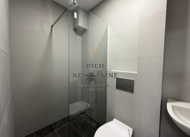 Moderne kupatilo sa tuš kabinom i ugradnom sanitarijom.