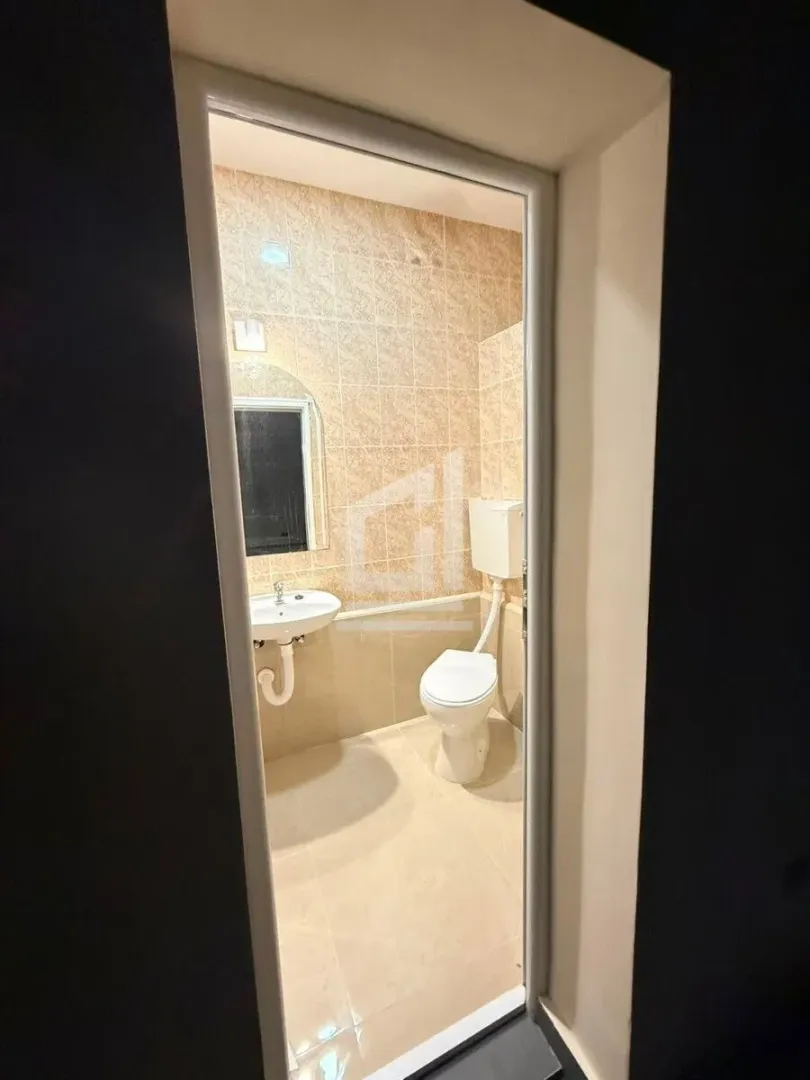 View through the doorway into the bathroom with a sink and toilet.