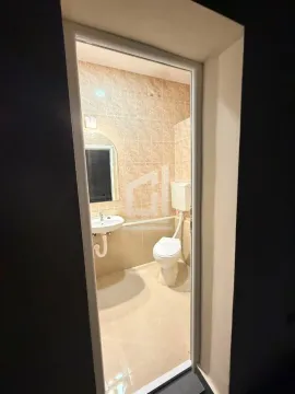 View through the doorway into the bathroom with a sink and toilet. - image 3