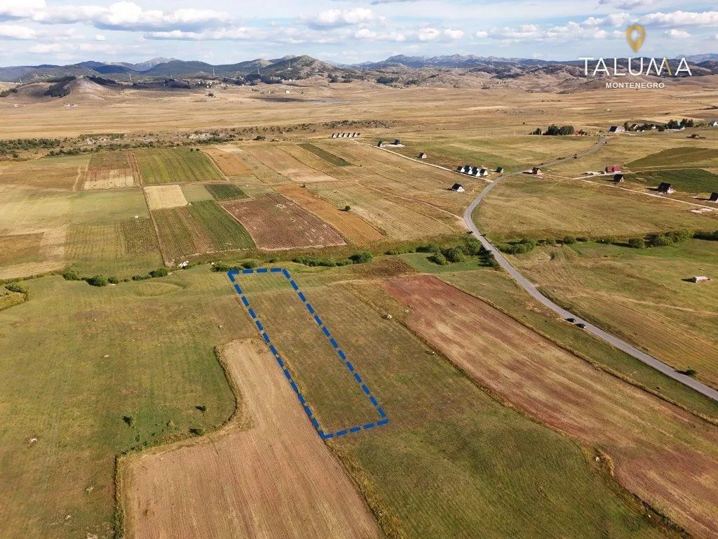 Pogled iz vazduha na zemljište sa ucrtanim granicama parcele i okolnim pejzažem.