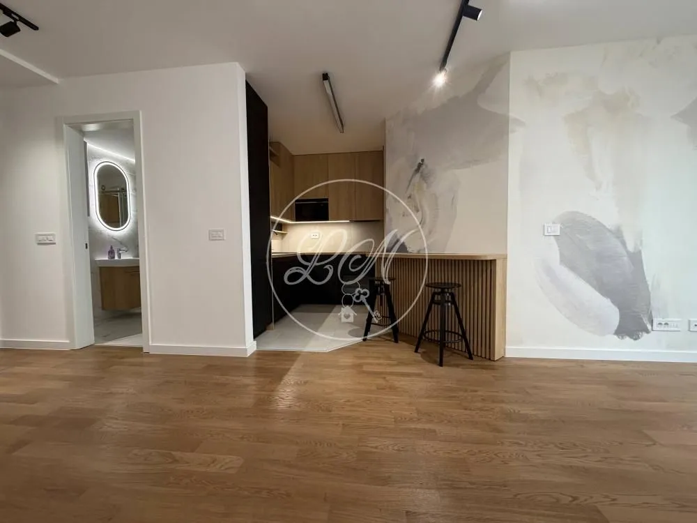 Living room with a view of the kitchen and bathroom entrance.