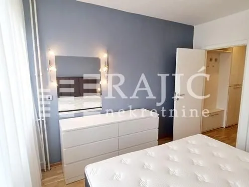 Furnished bedroom with a bed and a dresser.