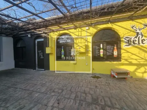 Exterior of the commercial space with a yellow facade and paved courtyard. - image 10