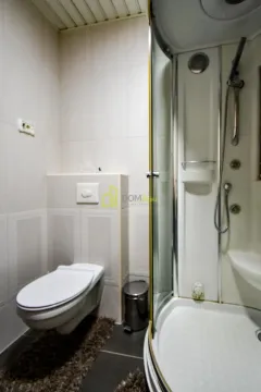 Bathroom equipped with a toilet and a shower cabin. - image 26