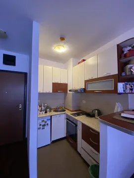 A small functional kitchen with white and brown cabinets. - image 8