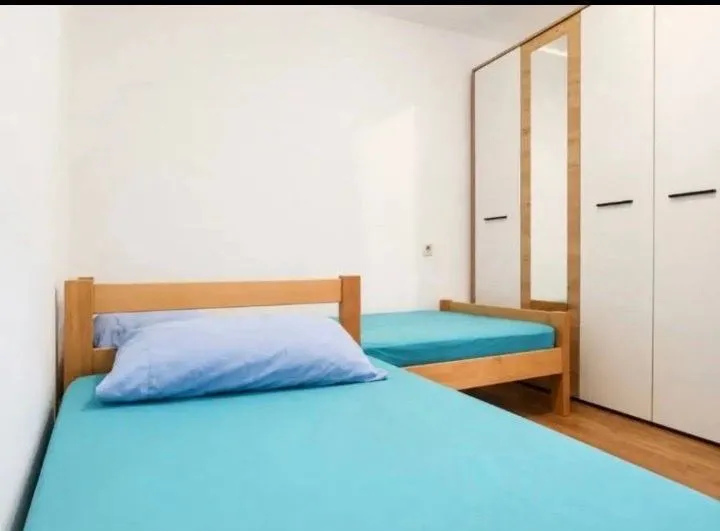 Bedroom with two beds and a white wardrobe.