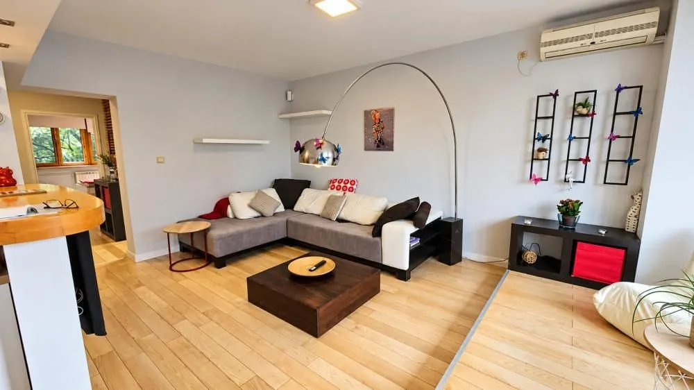 Living room with a sectional sofa, coffee table, and decorative wall elements.