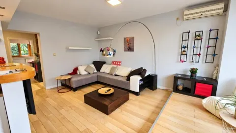 Living room with a sectional sofa, coffee table, and decorative wall elements. - image 3