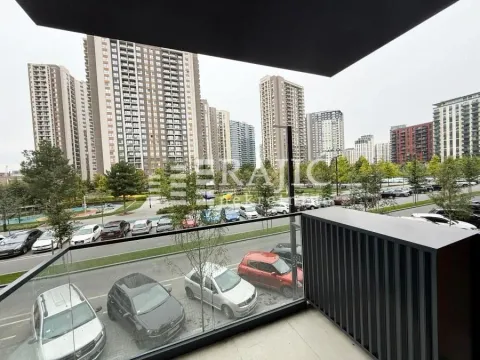 View from the balcony overlooking city buildings and parking. - image 4