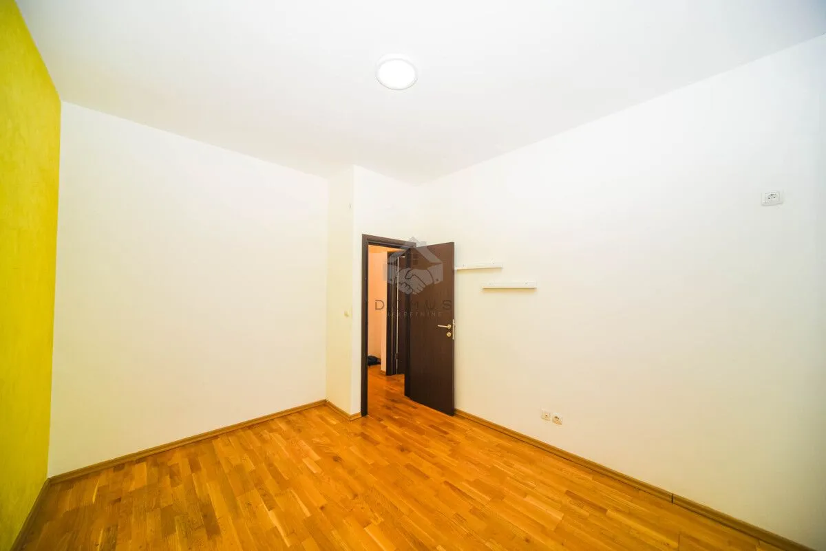 Empty room with hardwood floors and an open door.
