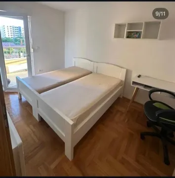 Spavaća soba sa dva kreveta i radnim stolom. - image 2