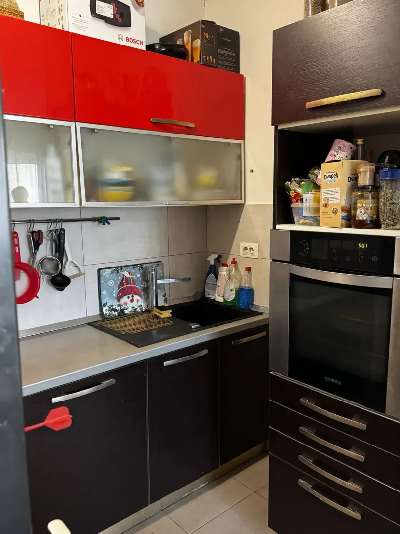 Manja kuhinja sa sudoperom, radnom površinom i ugradnom rernom.