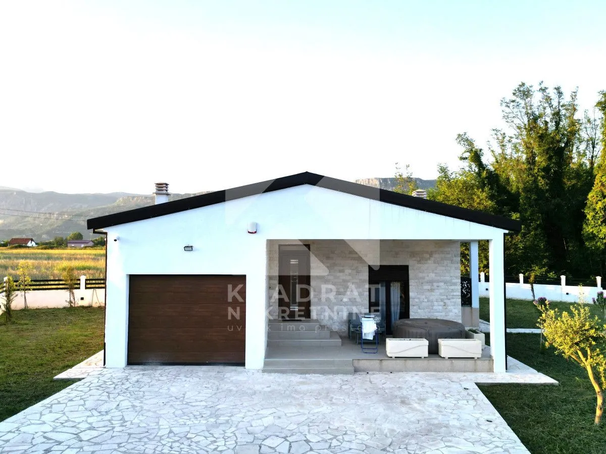 Front view of the house with a garage, paved courtyard, and terrace.