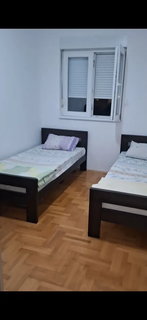 Spavaća soba sa dva kreveta na sprat i drvenim parketom.