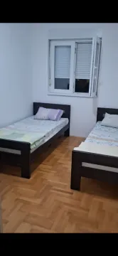 Spavaća soba sa dva kreveta na sprat i drvenim parketom. - image 4
