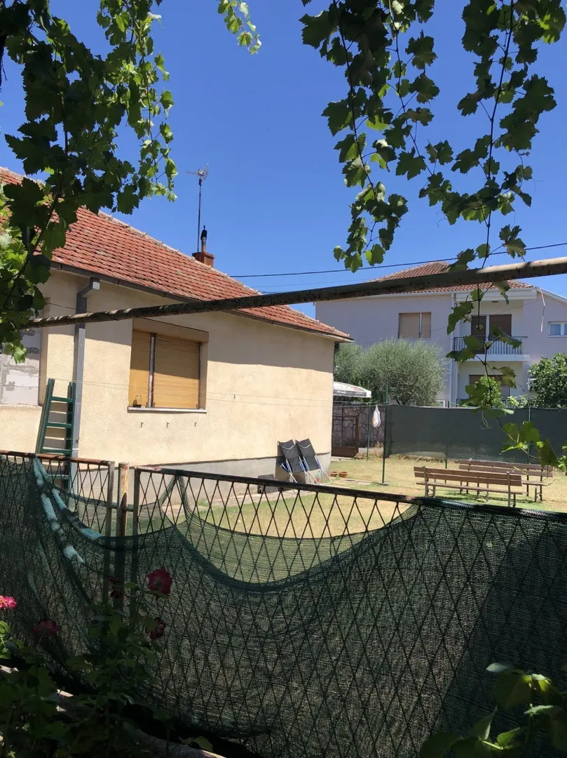 Dvorište i spoljašnjost kuće pod sunčanim nebom.