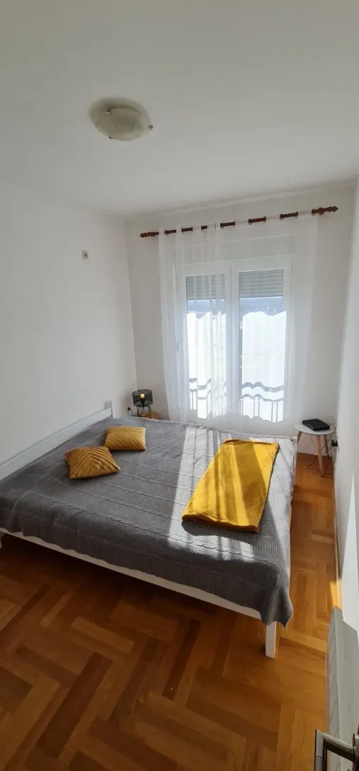 Svijetla spavaća soba sa bračnim krevetom.