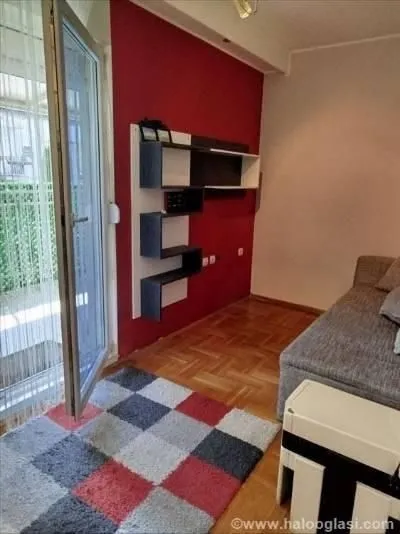 Dnevna soba sa garniturom za sedenje i izlazom na terasu.