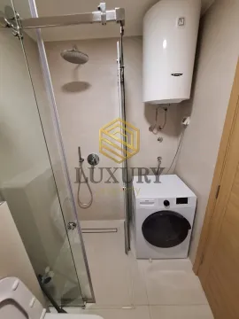 Modernly equipped bathroom with a shower cabin and washing machine. - image 6
