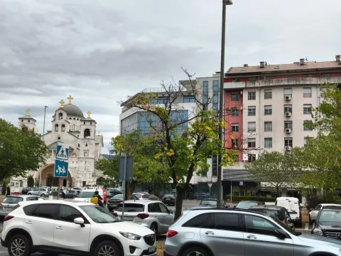 View of the city square and surrounding buildings with a parking lot in the foreground. - image 3