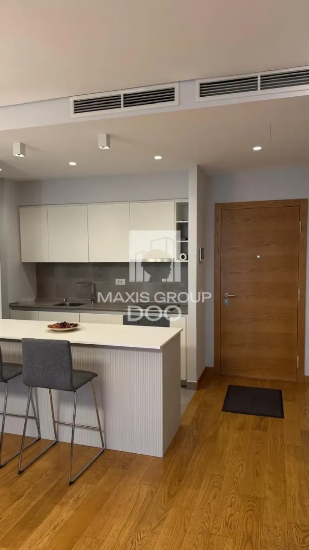 Modern kitchen with a breakfast bar and wooden floor.