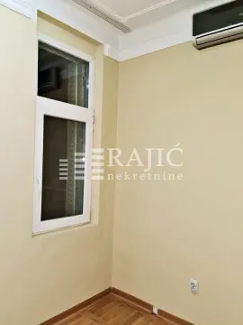 Empty room with parquet flooring, a white window, and an air conditioning unit. - image 5