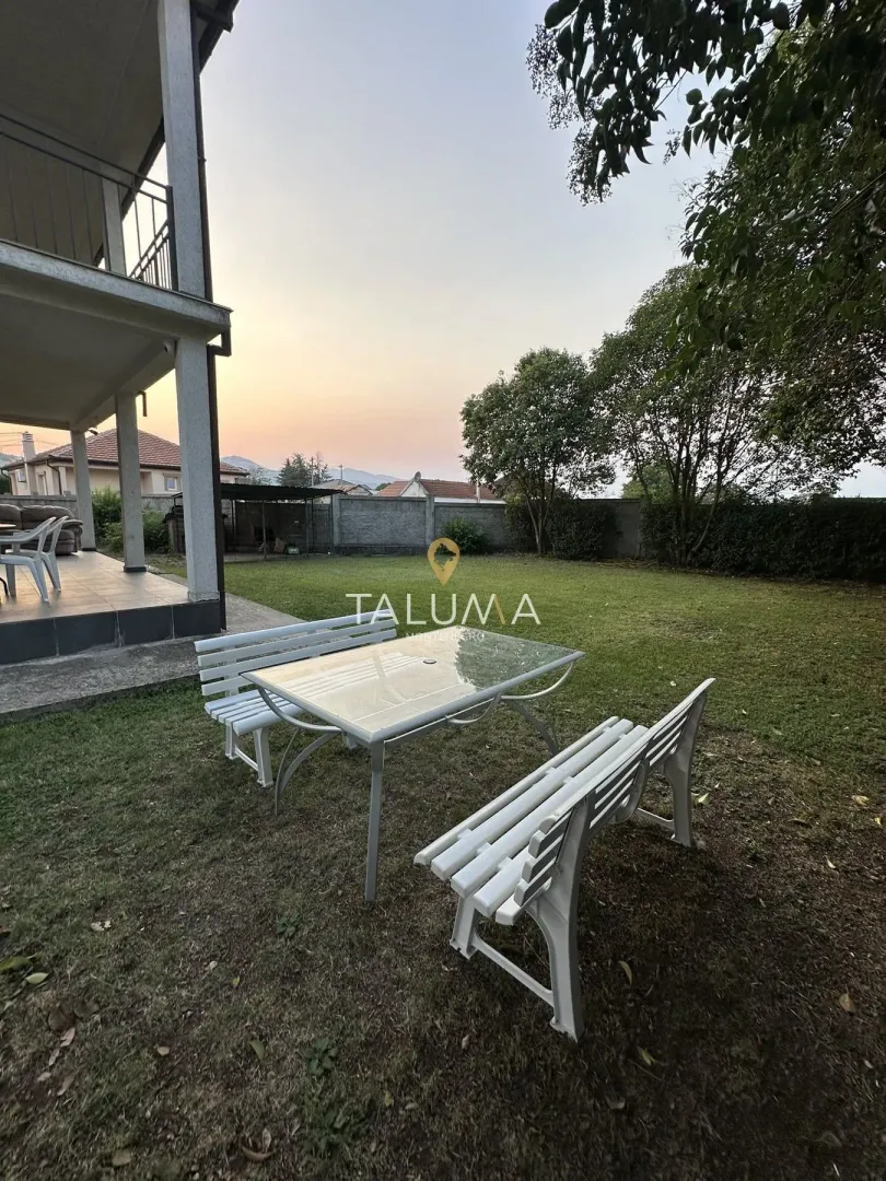 House yard with seating furniture and a lawn.