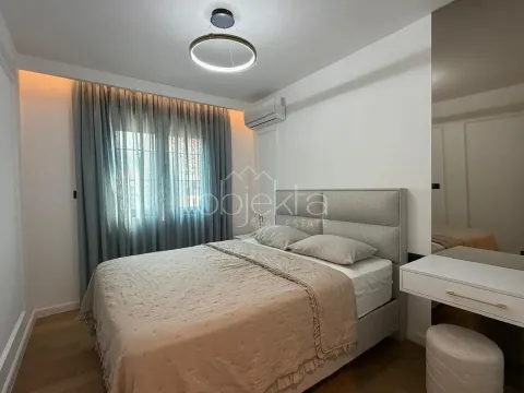 Furnished bedroom with a double bed, curtains, and built-in lighting. - image 8