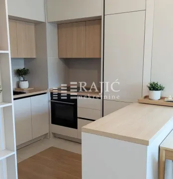 Modern and tidy kitchen with built-in appliances and a bar counter. - image 4