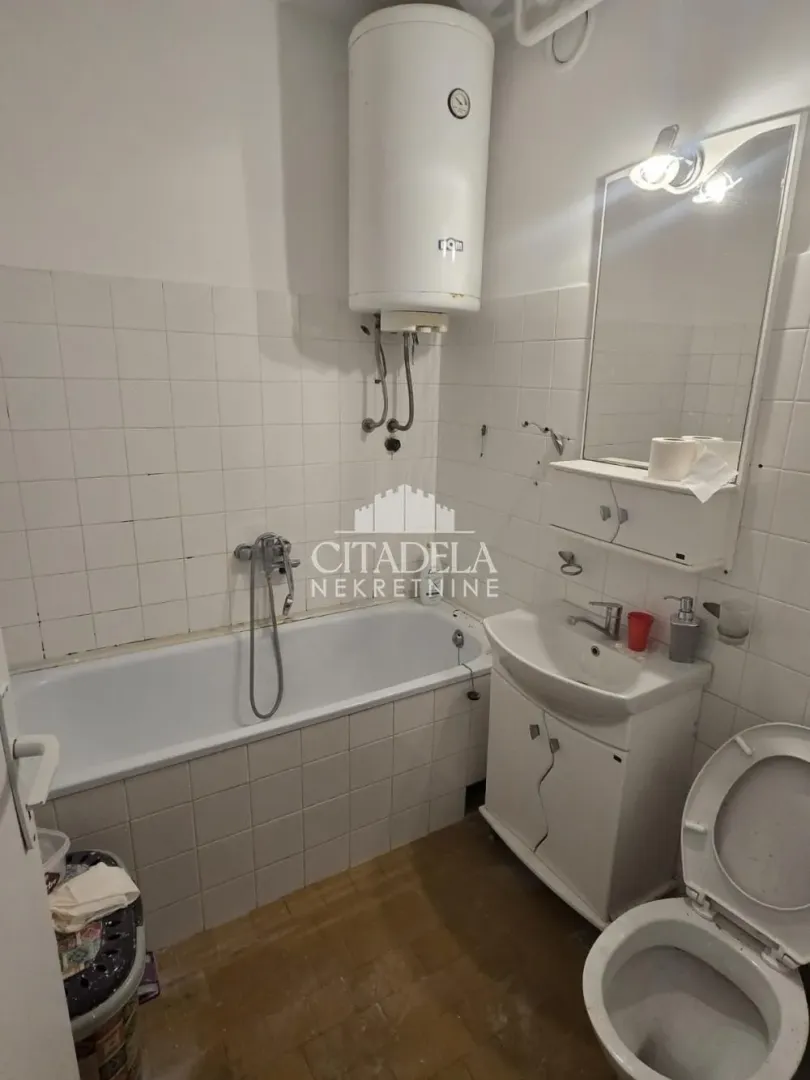 Manje kupatilo sa kadom, umivaonikom i bojlerom.