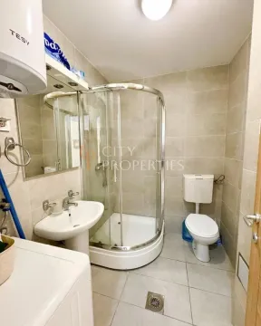 Compact bathroom with a shower cabin, washbasin, toilet, and water heater. - image 9
