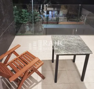 Covered terrace with a table and a wooden armchair. - image 7
