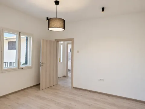 Empty bright room with wooden flooring, white walls and an open door. - image 5