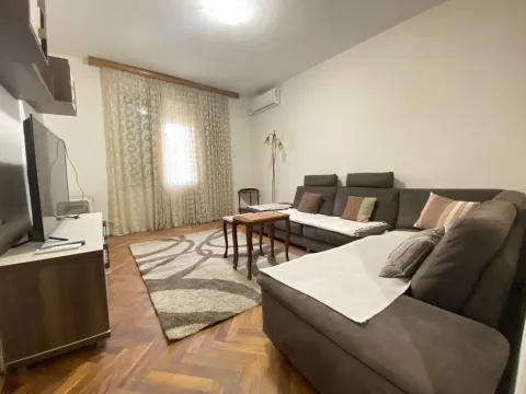 Svijetla dnevna soba sa prostranom ugaonom garniturom, klub stolom i televizorom. - image 2